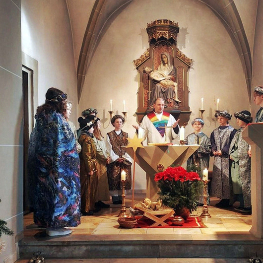 Um den Altar stehen die Sternsingerinnen und Sternsinger sowie Pastoralreferent Florian Meier.